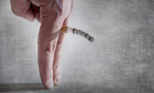 Holding cigarette between fingers depicting erectile dysfunction